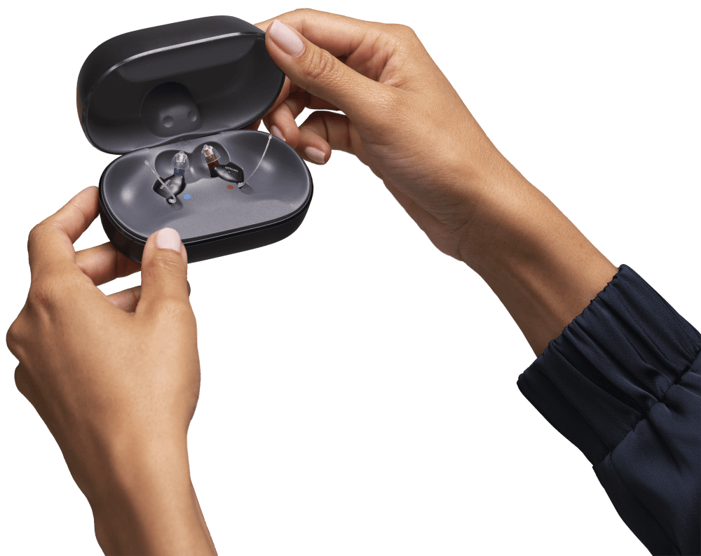 Oticon_Zeal_Open_Charger_with_Product_in_Hand_KC_25_24226