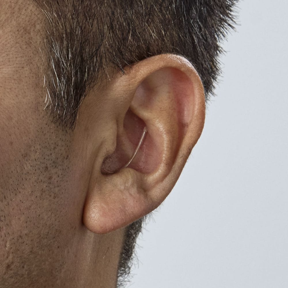 Oticon_Zeal_nxtCIC_H2-2025_AngleF45_Close-up_In-On-Ear_MS1572_Man